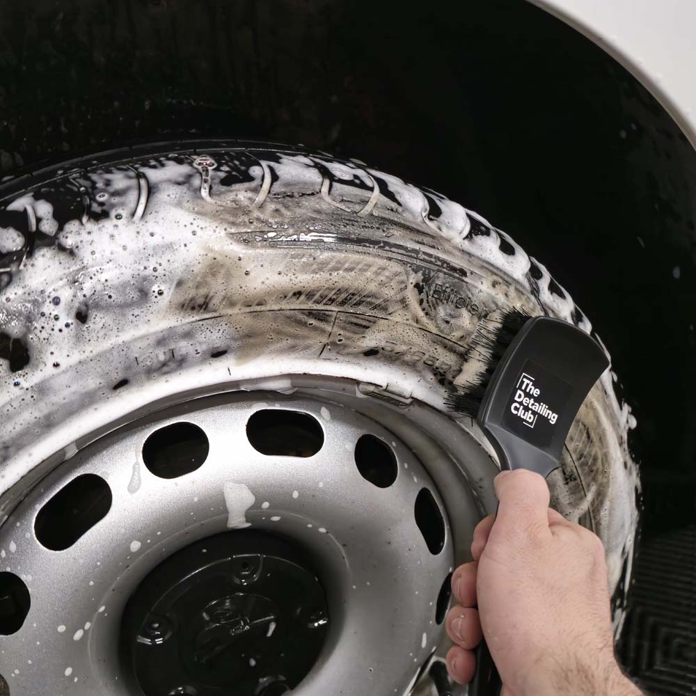 Detailer frotando neumático con cepillo de cerdas de nylon y espuma limpiadora